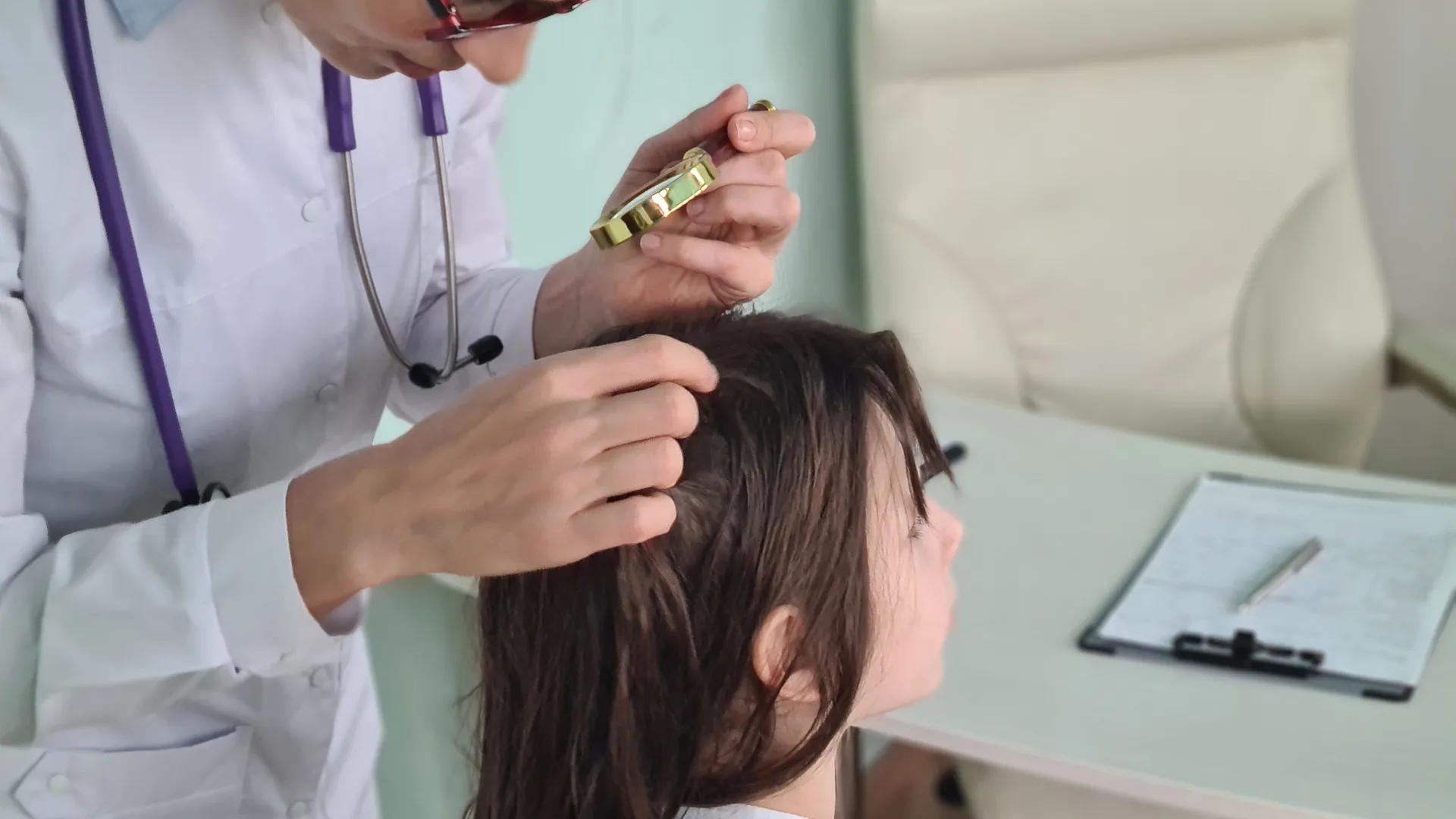 Medical professional examining a child's scalp after a school head lice notice