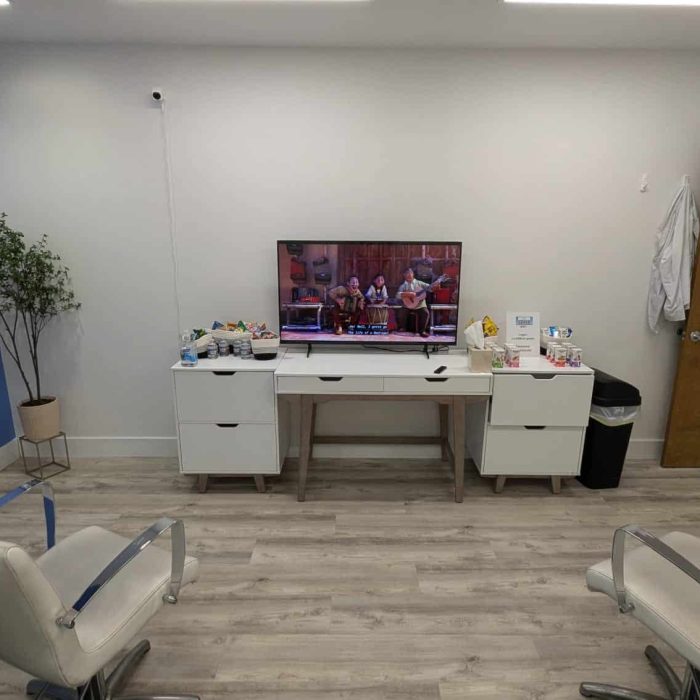 Treatment image by Lice Lifters Of Bucks County - Lice Treatment and Lice Removal Two reclining chairs facing a television on a low white cabinet.