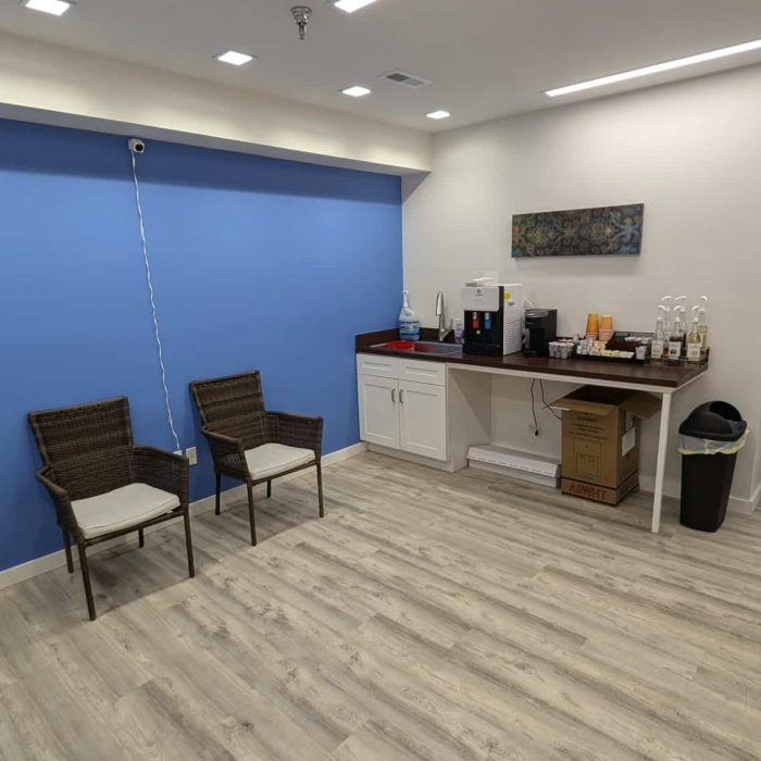 Treatment image by Lice Lifters Of Bucks County - Lice Treatment and Lice Removal Chairs along a blue wall beside a counter, shelving and a sink.