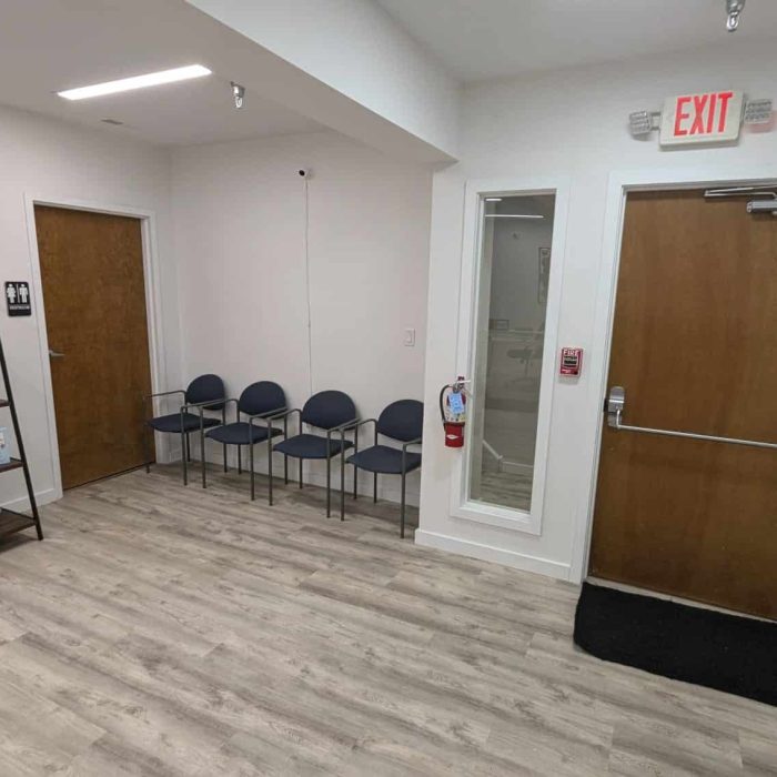 Treatment image by Lice Lifters Of Bucks County - Lice Treatment and Lice Removal Interior entrance area with a row of chairs, display shelving and an exit door.
