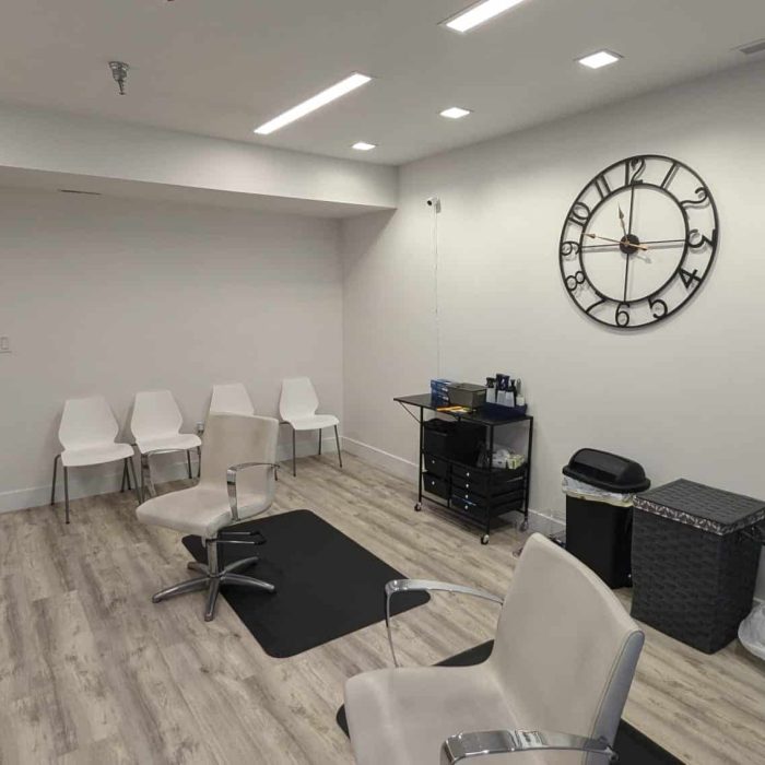 Treatment image by Lice Lifters Of Bucks County - Lice Treatment and Lice Removal Reclining chairs and storage carts in a room with a large round wall clock.